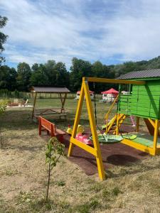 a playground with a slide and a swing at Apartament Amis tip Cabana in Poeni