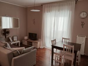 a living room with a table and a couch and a clock at Primo Piano in Enna