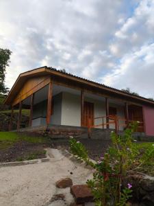 a small house with a roof on a field at Casa com dois quartos cama de casal e vista panorâmica próximo a Gramado Serra Gaúcha in Igrejinha