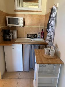a small kitchen with a white refrigerator and a microwave at Launie Lea Chambre d'Hotes in Eyzerac