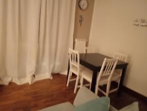 a dining room with a black table and white chairs at Primo Piano in Enna