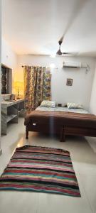 a bedroom with a bed and a rug at Minx guest house in Candolim
