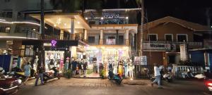 a group of people walking down a street at night at Minx guest house in Candolim