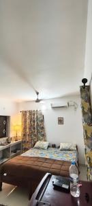 a bedroom with a bed and a table in it at Minx guest house in Candolim +3 photos