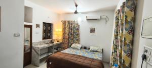 a small bedroom with a bed and a sink at Minx guest house in Candolim