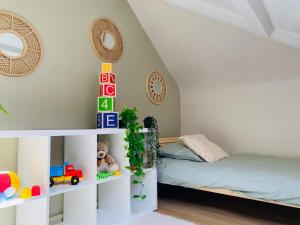 a childs room with a bed and a white shelf at Les Bons Vivants - L'appartement in Trouville-sur-Mer