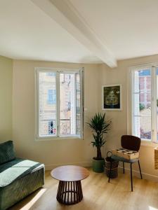 a living room with a couch and a table at Les Bons Vivants - L'appartement in Trouville-sur-Mer