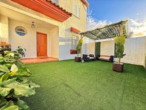 a patio with green grass and plants in a house at Ronko House El Ronquillo in El Ronquillo