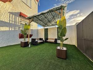 a patio with two potted plants on the grass at Ronko House El Ronquillo in El Ronquillo