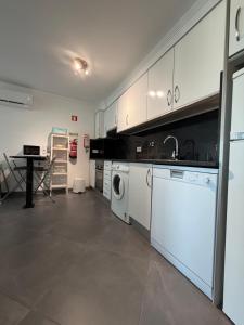 a kitchen with a washer and a sink and a dishwasher at Vela Terrace in Monte Gordo