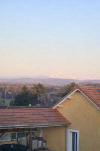 a view of a house with mountains in the background at L'escale Aéro Lyon in Saint-Laurent-de-Mure