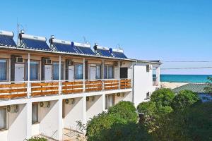 a building with solar panels on it next to the ocean at Микрон in Zatoka