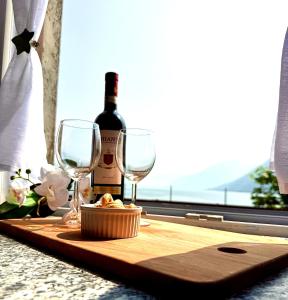 a table with a bottle of wine and two glasses at Como Lake View in Brienno +6 photos