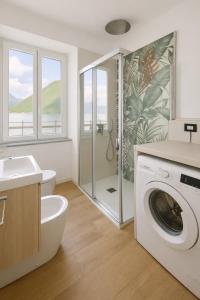 a bathroom with a sink and a washing machine at Como Lake View in Brienno
