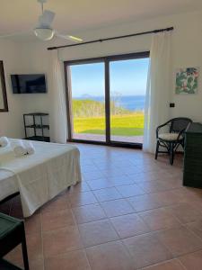 a bedroom with a bed and a large sliding glass door at GREEN APARTMENT in VILLA ANGISI in Drapia