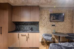a kitchen with a sink and a table with chairs at Basanavičiaus apartament in Vilnius