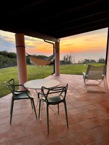 a patio with a table and two chairs and a hammock at GREEN APARTMENT in VILLA ANGISI in Drapia