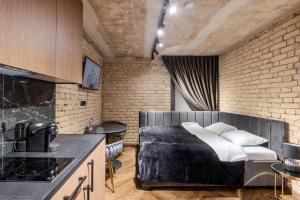 a bedroom with a bed and a brick wall at Basanavičiaus apartament in Vilnius