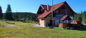 a house on a grassy field with afficientfficientfficientfficientfficient at Pensiunea Agroturistica Alexandra in Smida