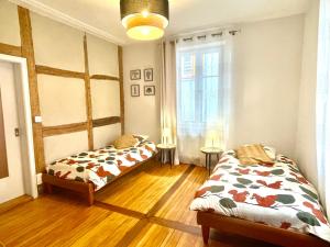 two beds in a room with wooden floors at Chez Schumi in Kirchheim