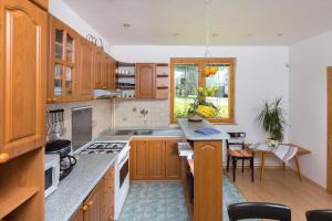 a large kitchen with wooden cabinets and a table at Vila Kantor in Vyšné Hágy
