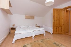 a bedroom with a bed and a wooden door at Vila Kantor in Vyšné Hágy