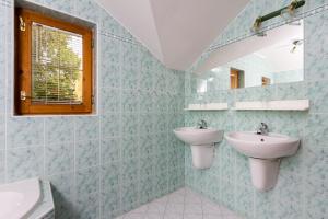 a bathroom with two sinks and a mirror at Vila Kantor in Vyšné Hágy