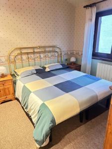 a bedroom with a bed with a blue and yellow blanket at Casa di David in Cerete