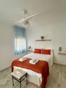 a white bedroom with a large bed with red pillows at Hispalis villa de Espartinas in Espartinas +16 photos