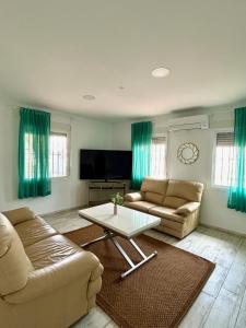 a living room with two couches and a coffee table at Hispalis villa de Espartinas in Espartinas