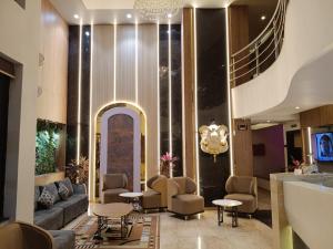 a lobby of a hotel with a couch and chairs at Hotel Vaishnavi in Solapur