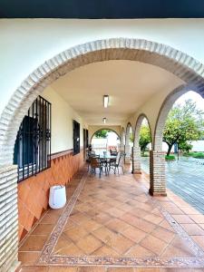 an arched patio with a table and chairs at Hispalis villa de Espartinas in Espartinas