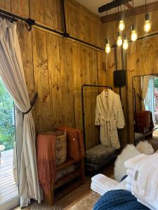 a bedroom with a wooden wall with a bed and a mirror at Espaço Áurea 60km de Curitiba com Cesta de Café da manhã in Campina Grande do Sul