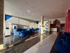 a lobby with blue chairs and tables in a building at شقق دازللشقق المخدومة in Hail