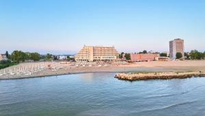 a beach with chairs and umbrellas and a beach at Apartament Faleza Nord in Constanţa
