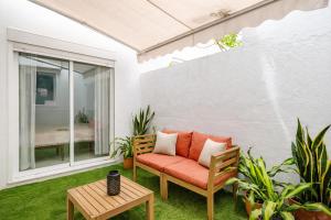 a patio with an orange couch and a table at Sofia Luxury Apartment in Seville