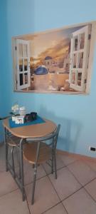 a table in a kitchen with a painting on the wall at Casa Giulia Affittacamere FORUM ASSAGO M2 M1 Milano CENTRO in Corsico