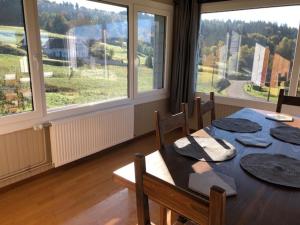 a dining room with a table and some windows at Chalet Belfahy in Belfahy