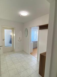 an empty room with a door and a tile floor at Möwennest in Barsbek