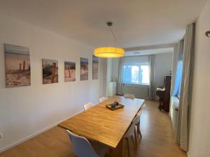 a dining room with a wooden table and chairs at Möwennest in Barsbek