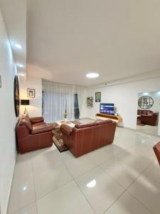 a living room with two leather couches and a television at Shave Tsion Apartment in the center Ashdod in Ashdod