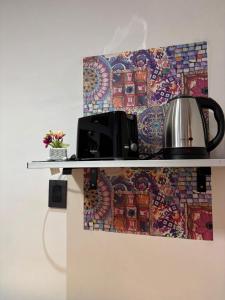 a tea kettle on a shelf with a mosaic wall at Sarr in Santa Fe +8 photos