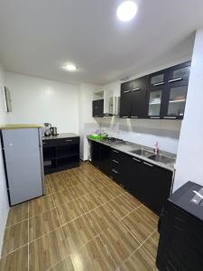 a kitchen with black cabinets and a wooden floor at Modern 2BR in Lekki Phase 1 in Lekki +6 photos