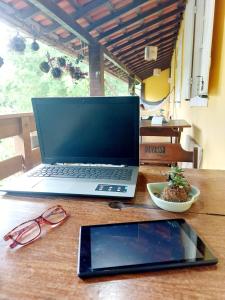 a laptop computer sitting on top of a wooden table at Hospedagem Casa do Bem Ficar in Lumiar