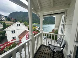 a porch with two chairs and a view of the water at Hofslund Fjord Hotel in Sogndal