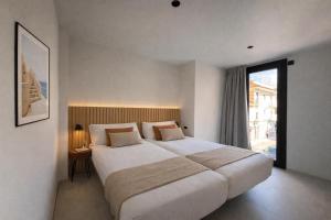 a bedroom with a large bed and a large window at Hugo Beach Hotel & Apartments in Gandía