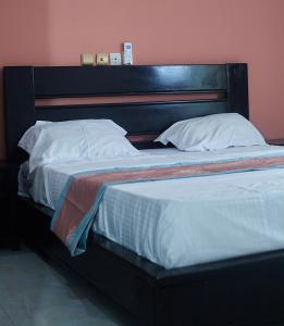 a large bed with a wooden headboard in a room at Résidence Inspire in Douala