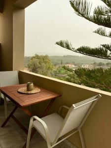 a table and chairs in a room with a window at Karadinos Apartment in Stílos