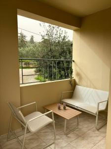 a balcony with a bench and a table and a window at Karadinos Apartment in Stílos +4 photos
