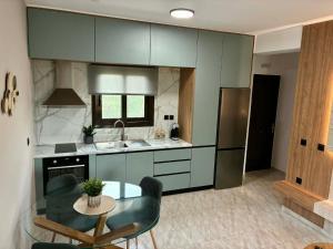 a kitchen with a glass table and a refrigerator at Karadinos Apartment in Stílos